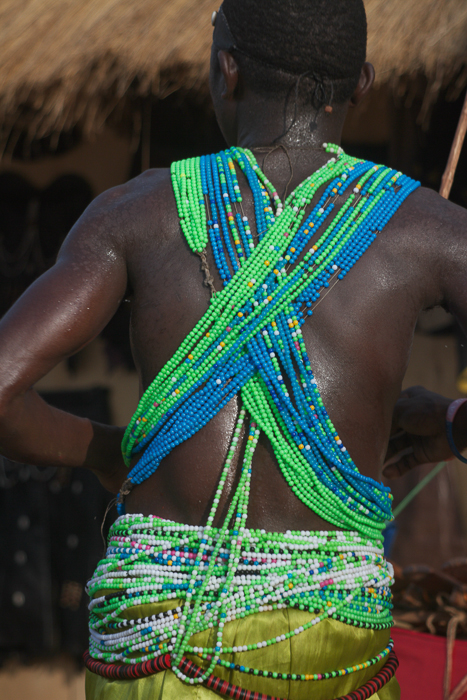 Vue de dos d’une participante portant une parure de perles, dans une danse patrimoniale mboum à Ngaoundéré